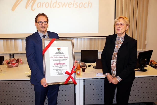 Bürgermeister Wolfram Thein überreicht an Susanne Kastner die Urkunde und ernennt sie zur Ehrenbürgerin der Marktgemeinde Maroldsweisach.
